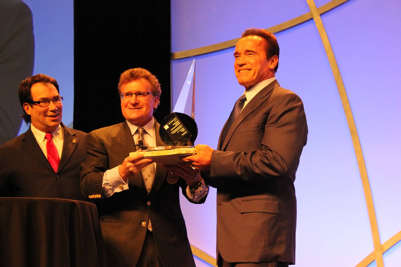 Governor Arnold Schwarzenegger receives the 2013 Infinity Award from A4M co-founders, Dr. Ronald Klatz and Dr. Robert Goldman