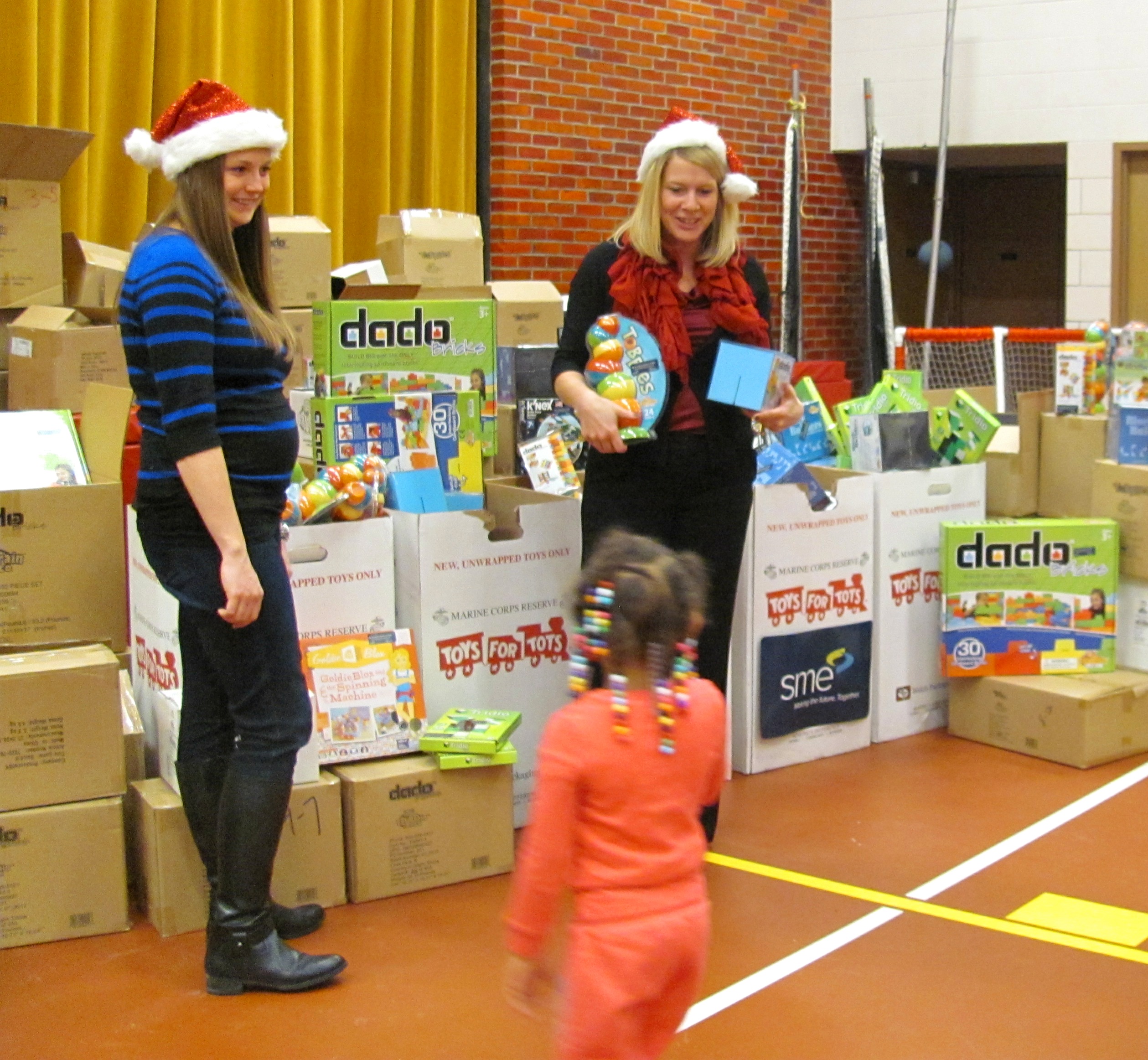 SME's Meghan Shea-Keenan (l) and Debbie Holton (r),give STEM toys to children at Toys for Tots in River Rouge, Mich.