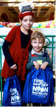 Eliana, 8 and Joseph, 4, of Scarsdale enjoy receiving their Ring in the New Year goodie backpack.