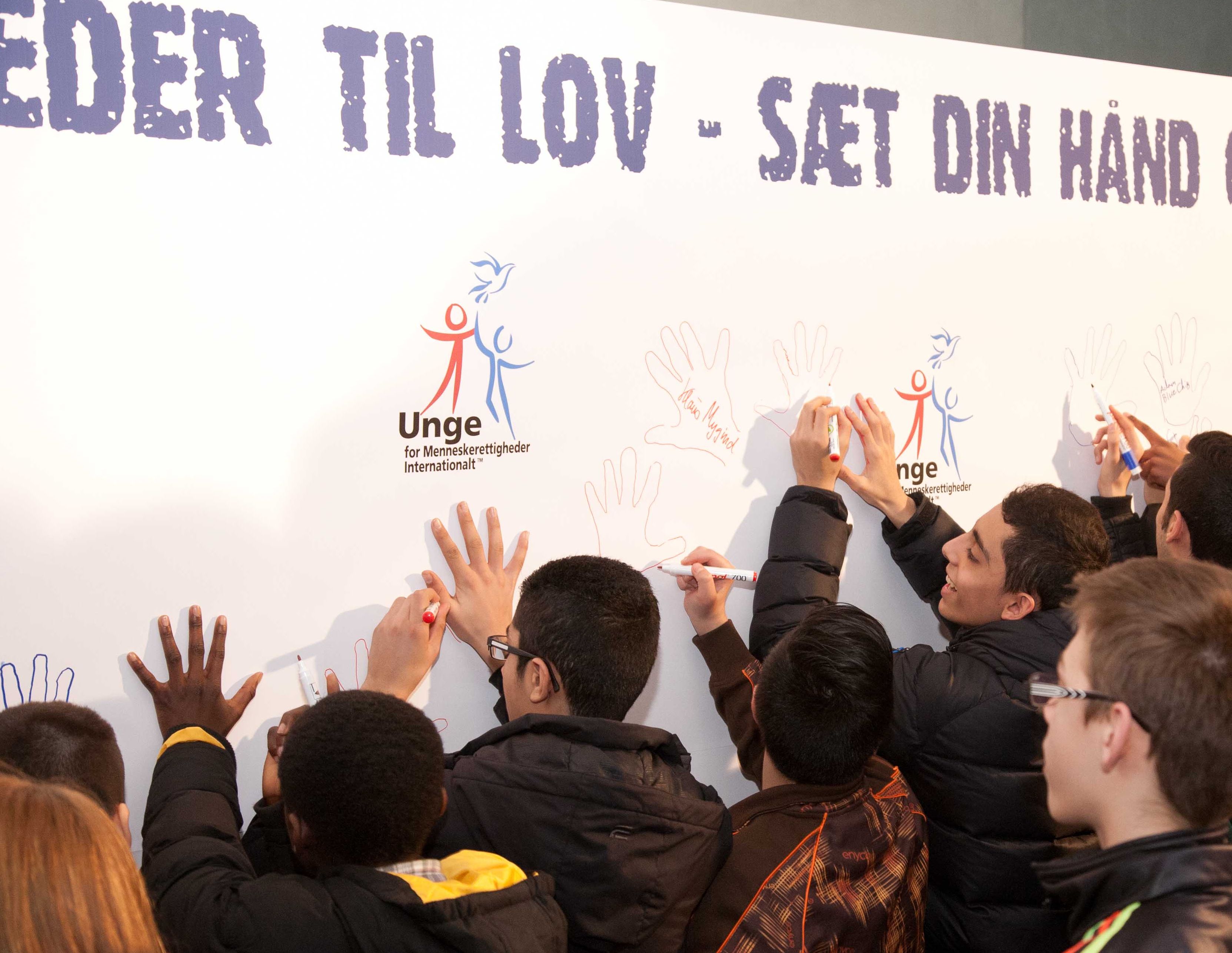 Youth traced their hands and wrote personal human rights messages on a mural to affirm their commitment to making human rights a fact.