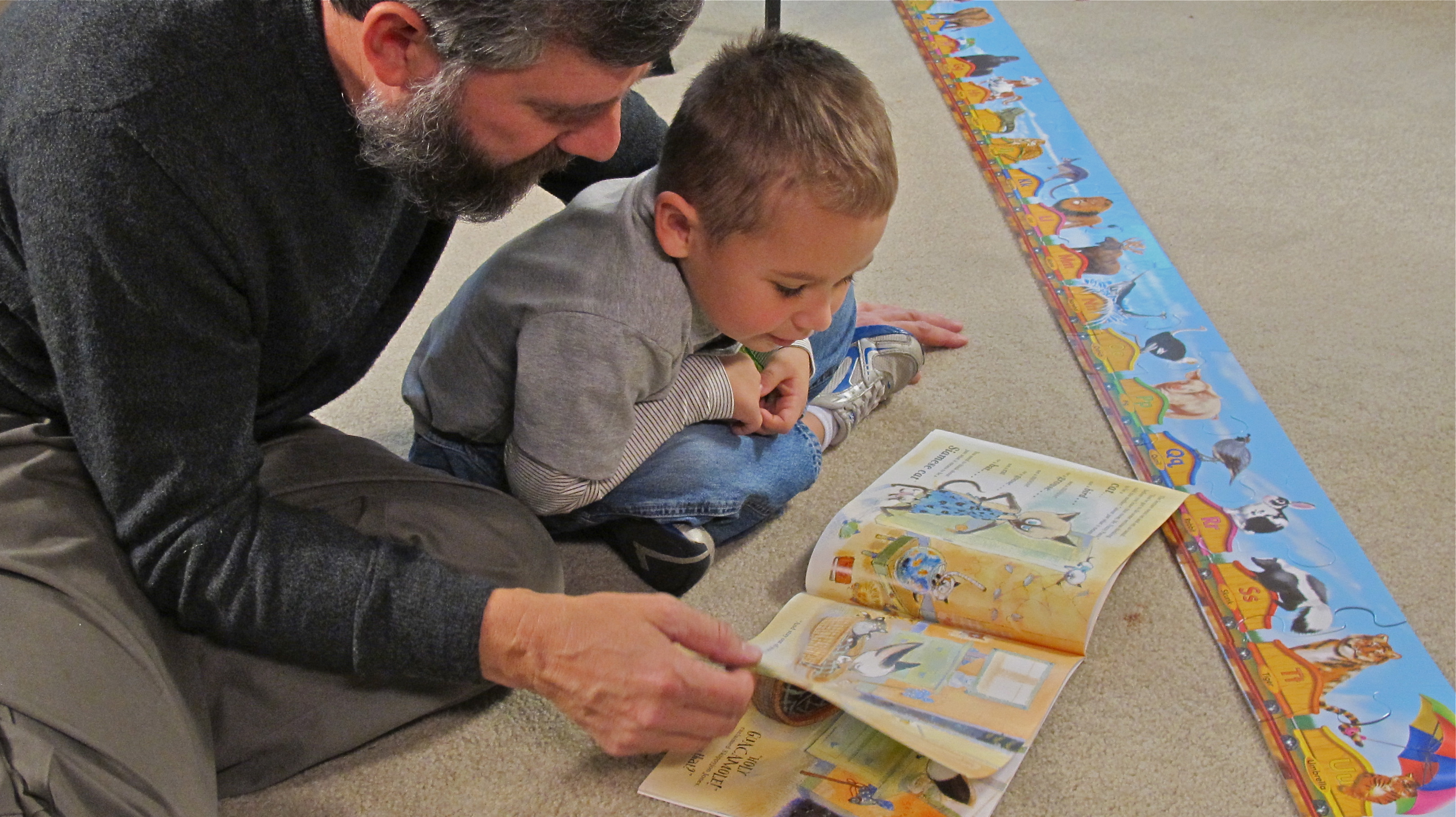 A READY! grandfather reads with his grandson.