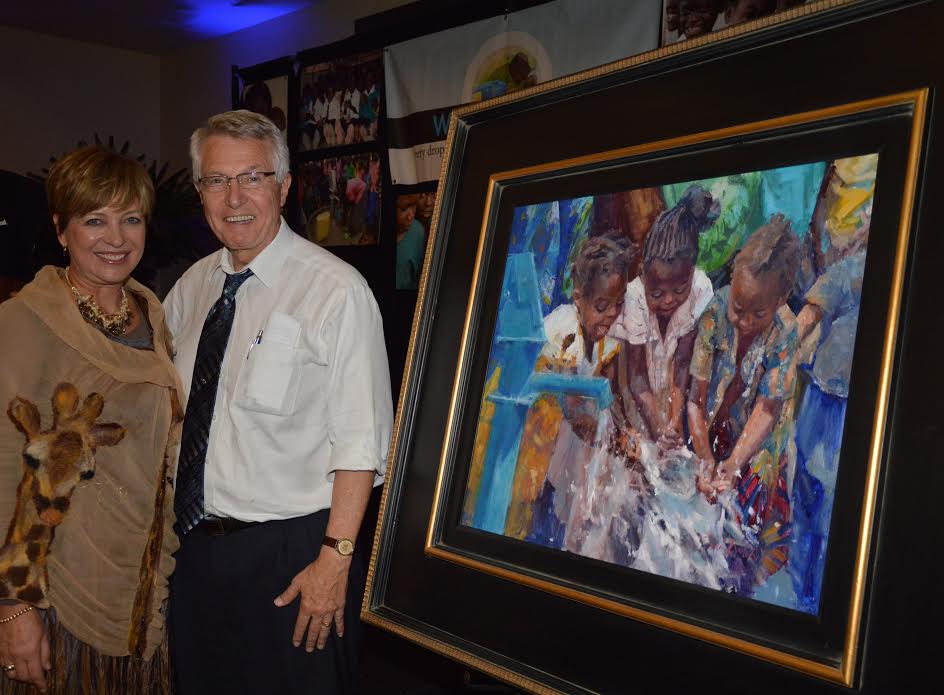 Toni Danchik, a local Orange County artist who created the signature piece “New Life at the Water Well”, celebrates with Pete Callahan, a Wells of Life board member on his winning bid.