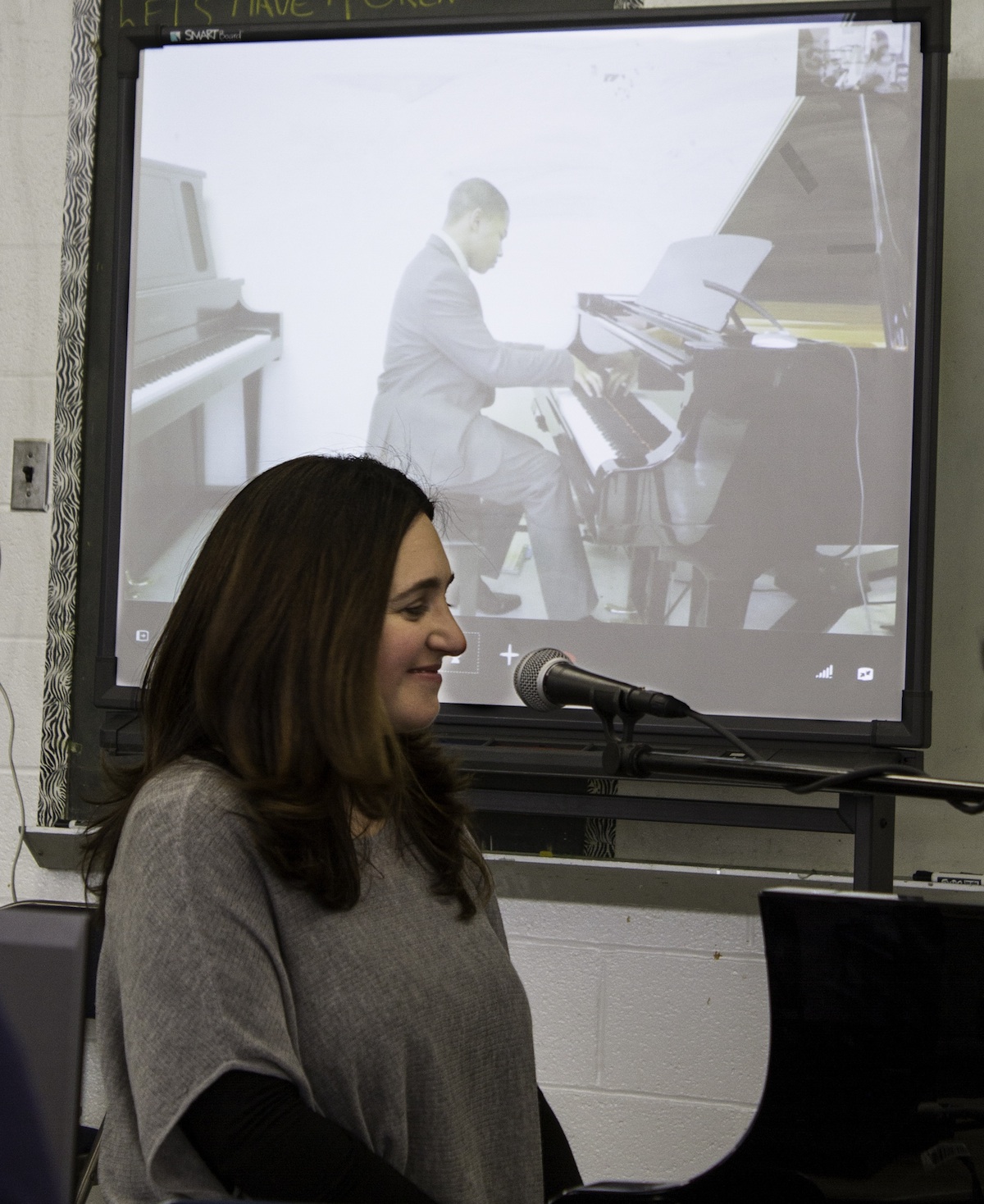 Simone Dinnerstein appears on a television monitor as she conducts a remote Disklavier piano lesson from Ballou High School to students located at Duke Ellington School of the Arts.