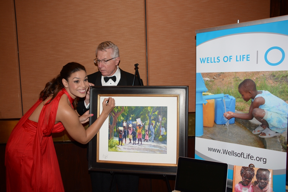Jorin Sparks signs a painting for Wells of Life, Platinum Sponsor for the First Annual Official Backstage MOVIEGUIDE® Awards Gifting Suite Experience
