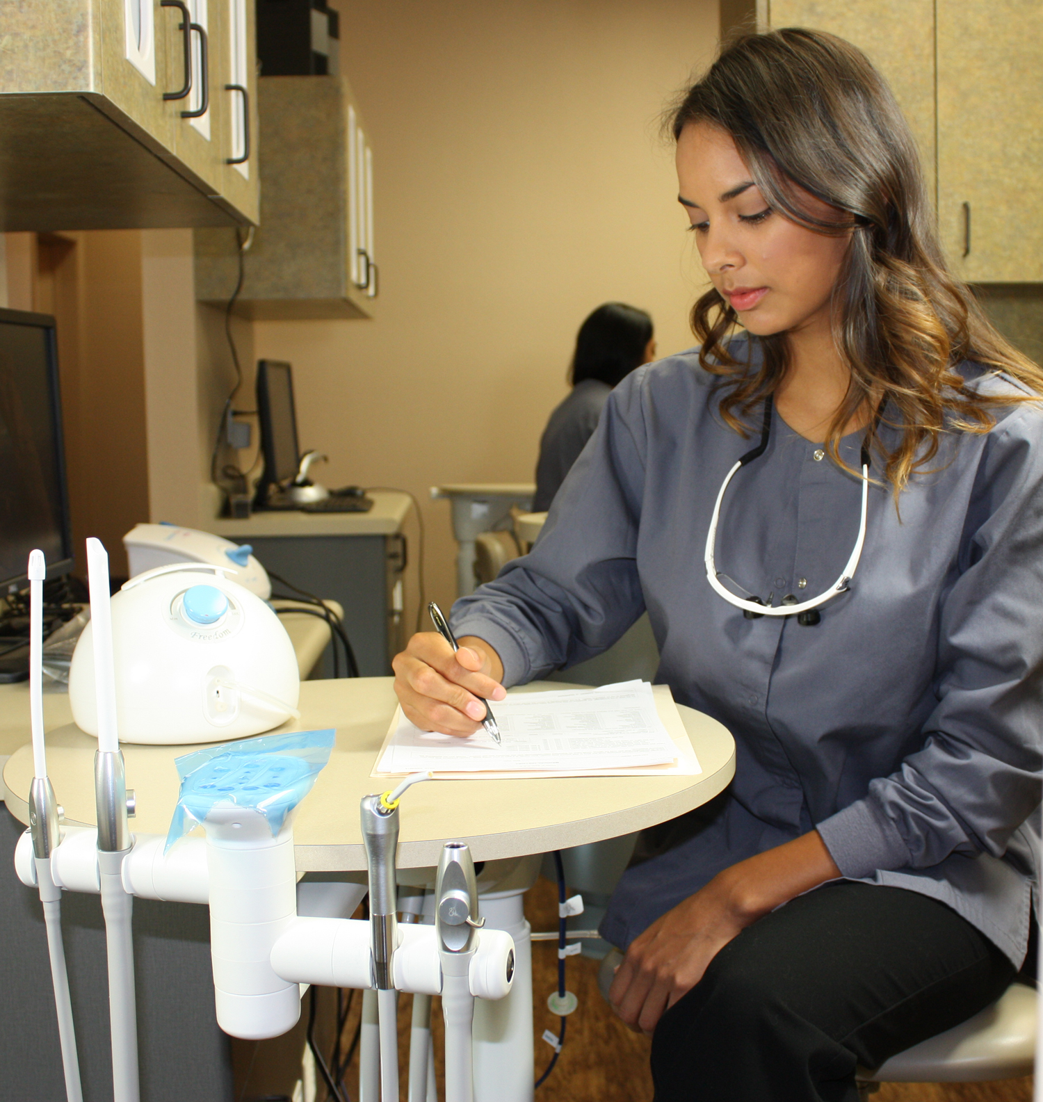 Dental assistant uses breast pump with clothes on while working
