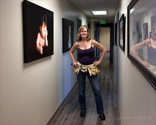 Linnea Lenkus hangs her artwork at the USC Perinatal Office.