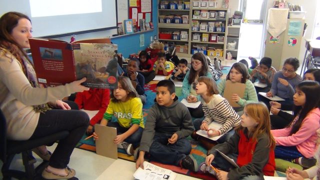 Ms. Lopata reads an historical fiction book to her fourth grade class.