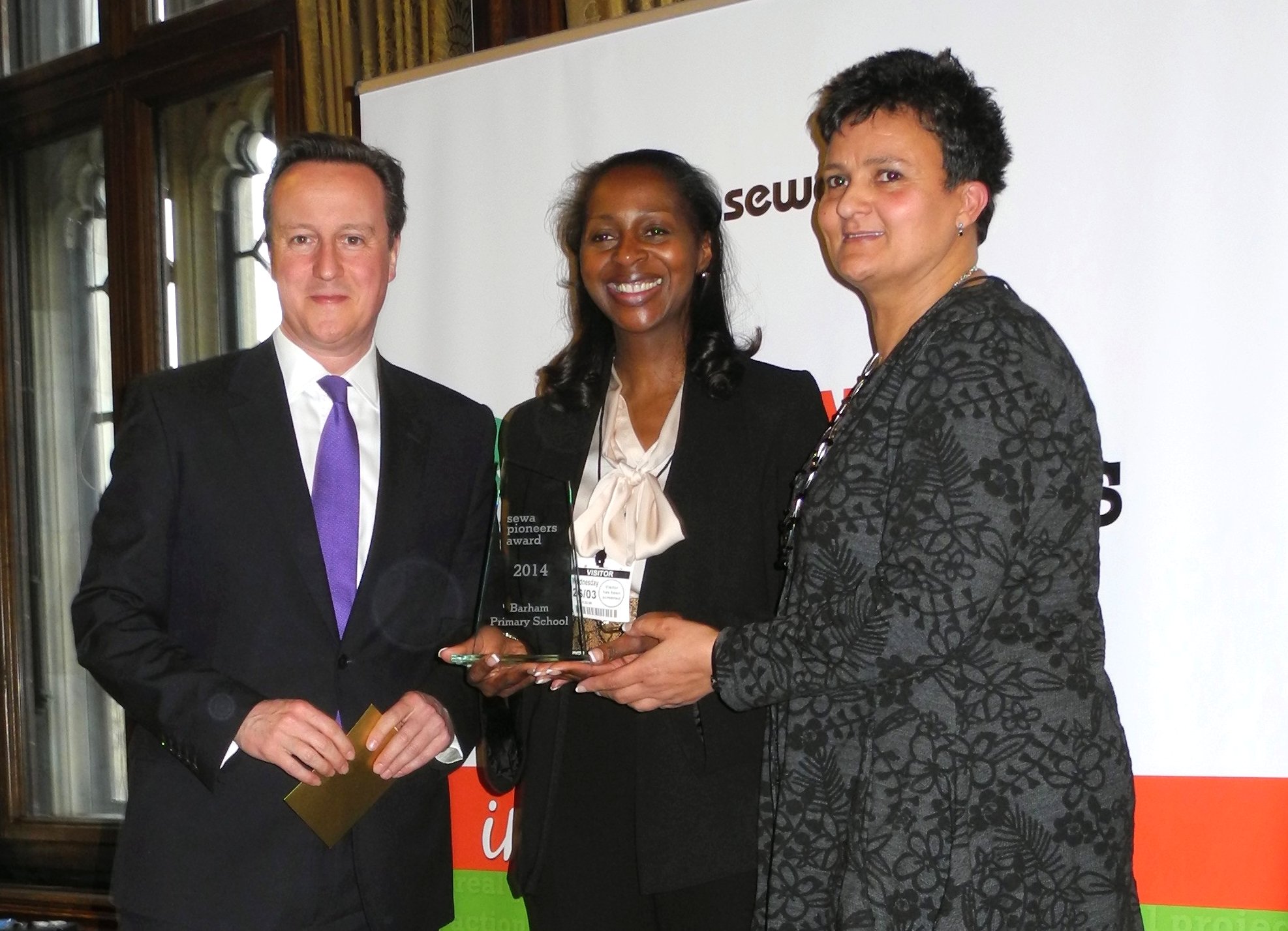 UK Prime Minister David Cameron presented an award to Karen Giles, Headteacher, and Ms Heaton from Barham Primary School. The school in Wembley has supported Sewa Day for the past three years.