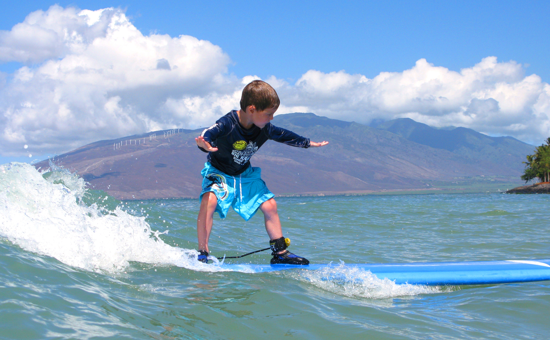 Six-year-old Ryan, who has leukemia, rides a surf board on his wish trip in Hawaii. Seventy-five percent of the wishes Make-A-WIsh grants involve travel making airline miles a critical resource.