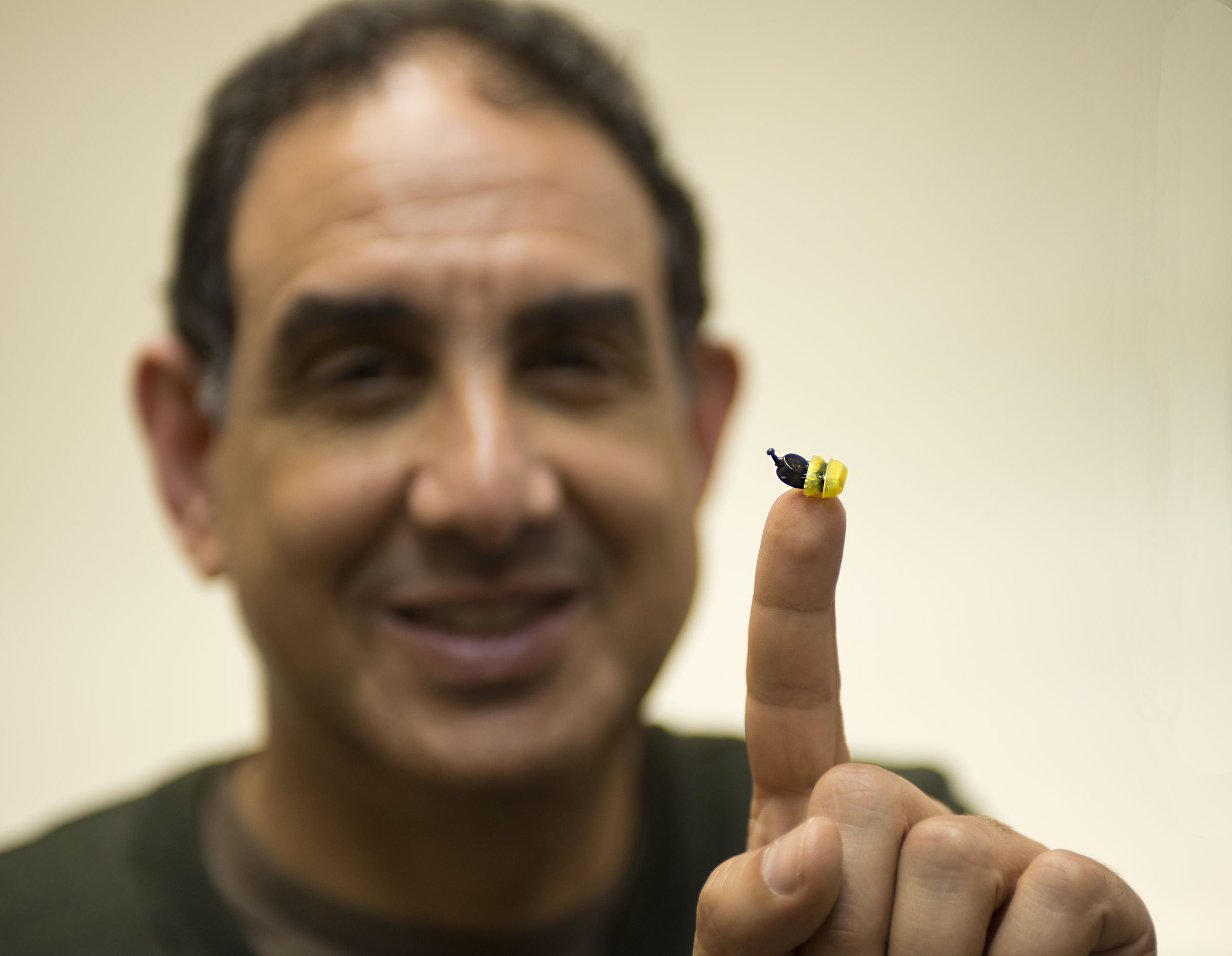 Adnan Shennib, iHear Medical CEO and founder, holds the iHear hearing aid on the tip of his finger.