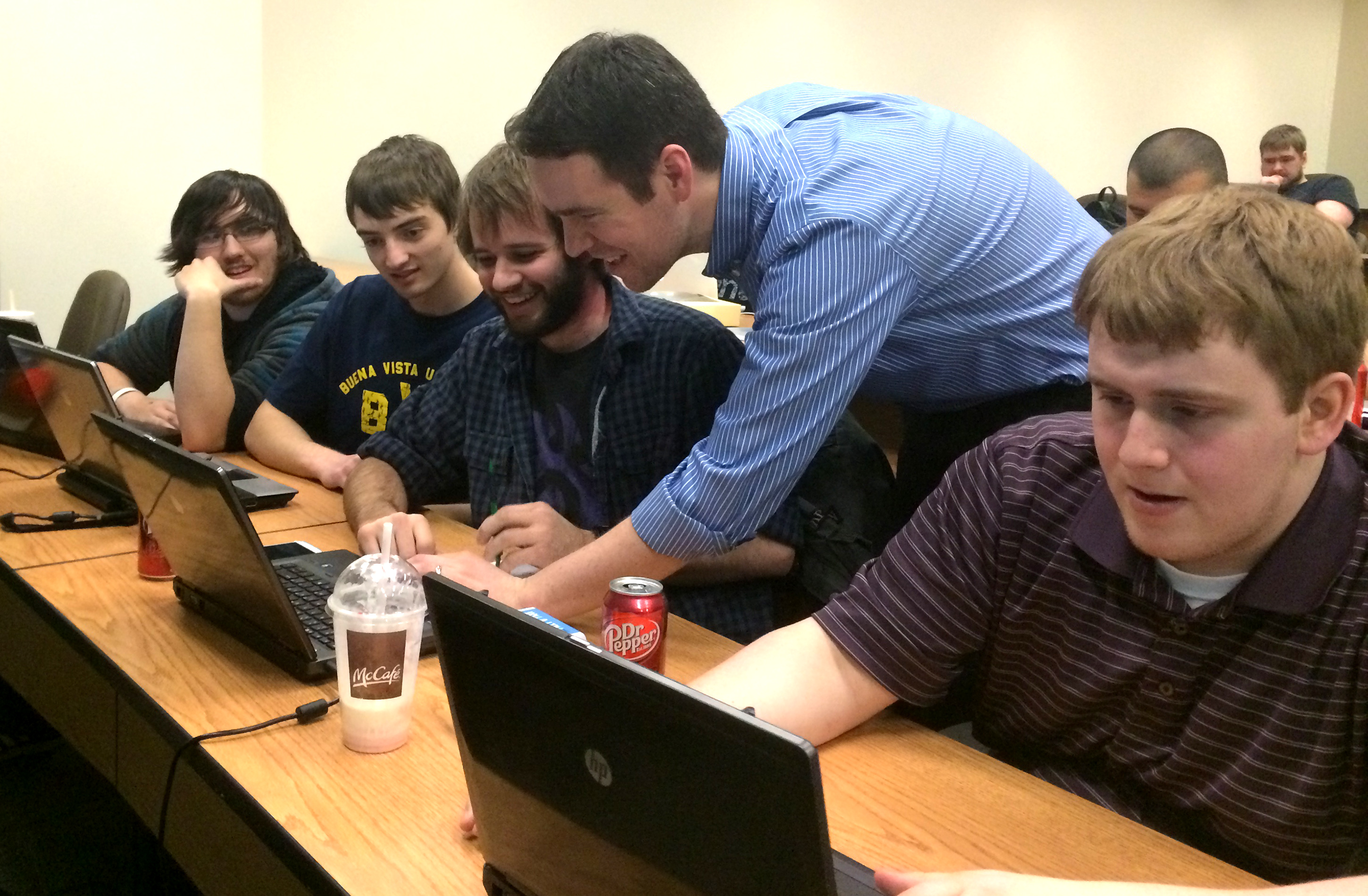 The winning BVU team in action, receiving input from Dr. Nathan Backman. From left to right: Alex Meier, Gerald Heylmun, Jonathan Kenkel, Dr. Nathan Backman and Arik Ostler