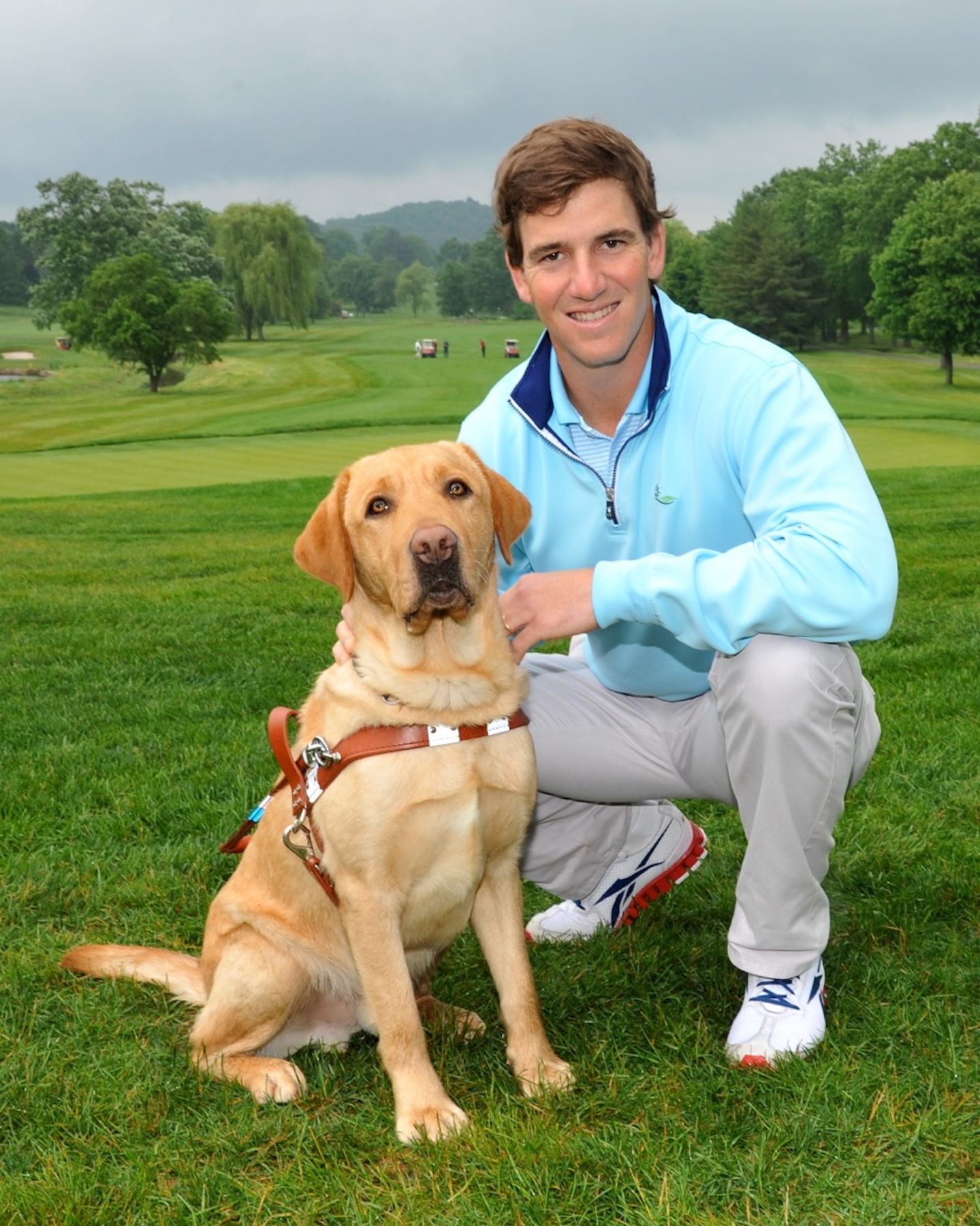 NY Giants Quarterback and eight-time Guiding Eyes for the Blind Golf Classic host Eli Manning with Guiding Eyes dog Taft. Photo by: John Vecchiolla