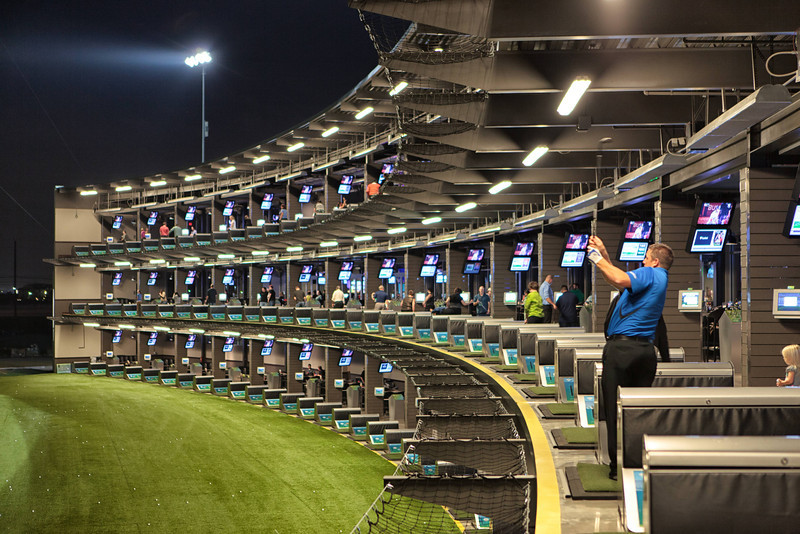 A golfer tees off at Topgolf
