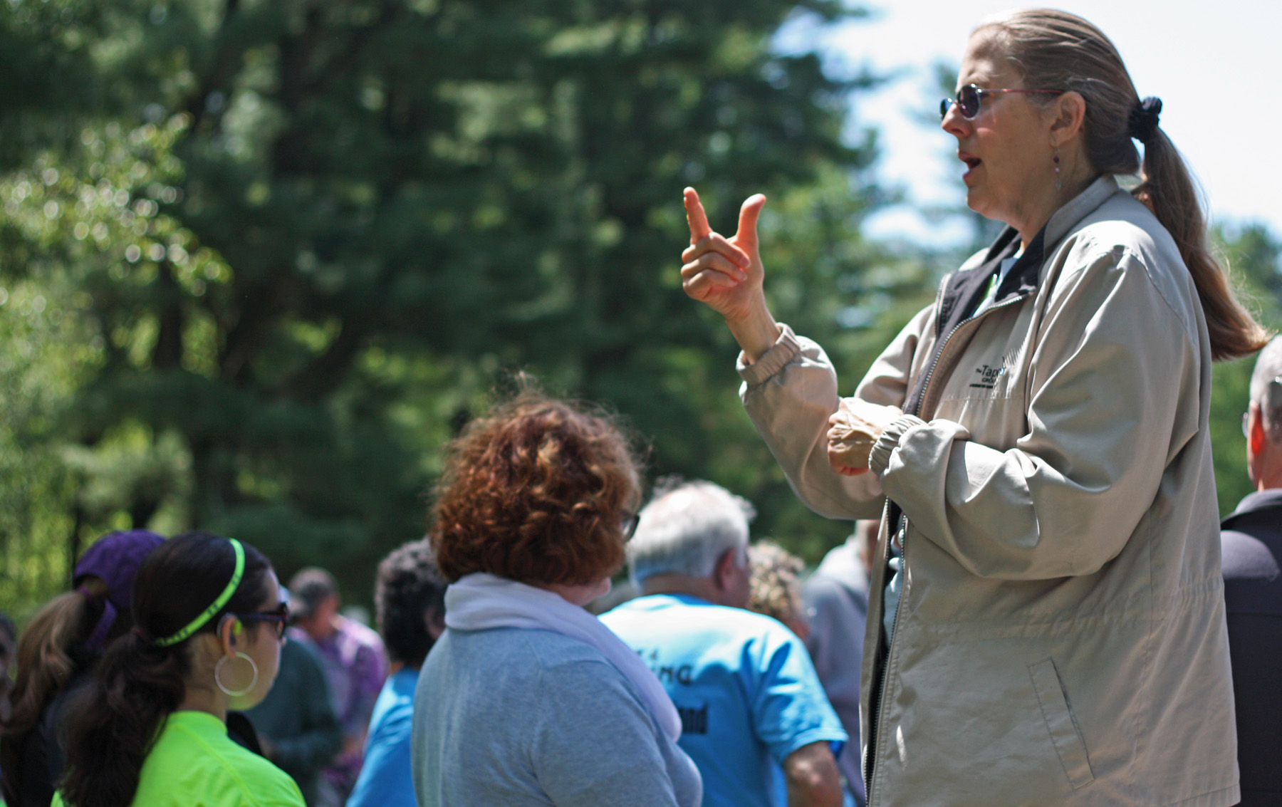 Sign language interpreter Eileen DeToma, standing, signs for the crowd of walkers at the 8th annual Westchester/Rockland Walk4Hearing, May 17 at FDR State Park.