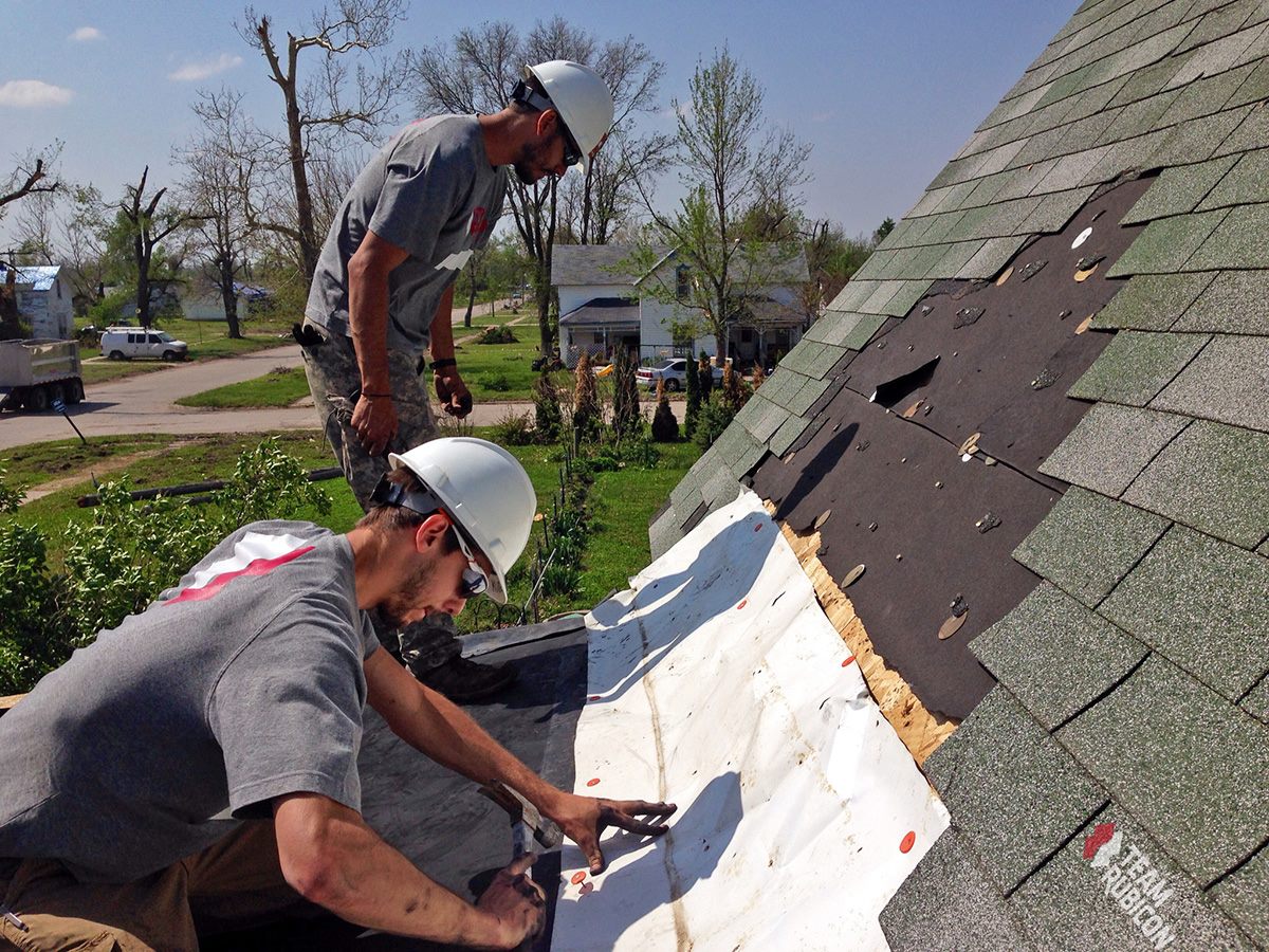 Team Rubicon volunteers Marshall Cloud and Michael Selivanoff help repair a roof in Beaver Crossing, Neb.