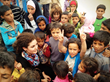 Hazami Barmada pictured with a group of Children in Zaatari camp