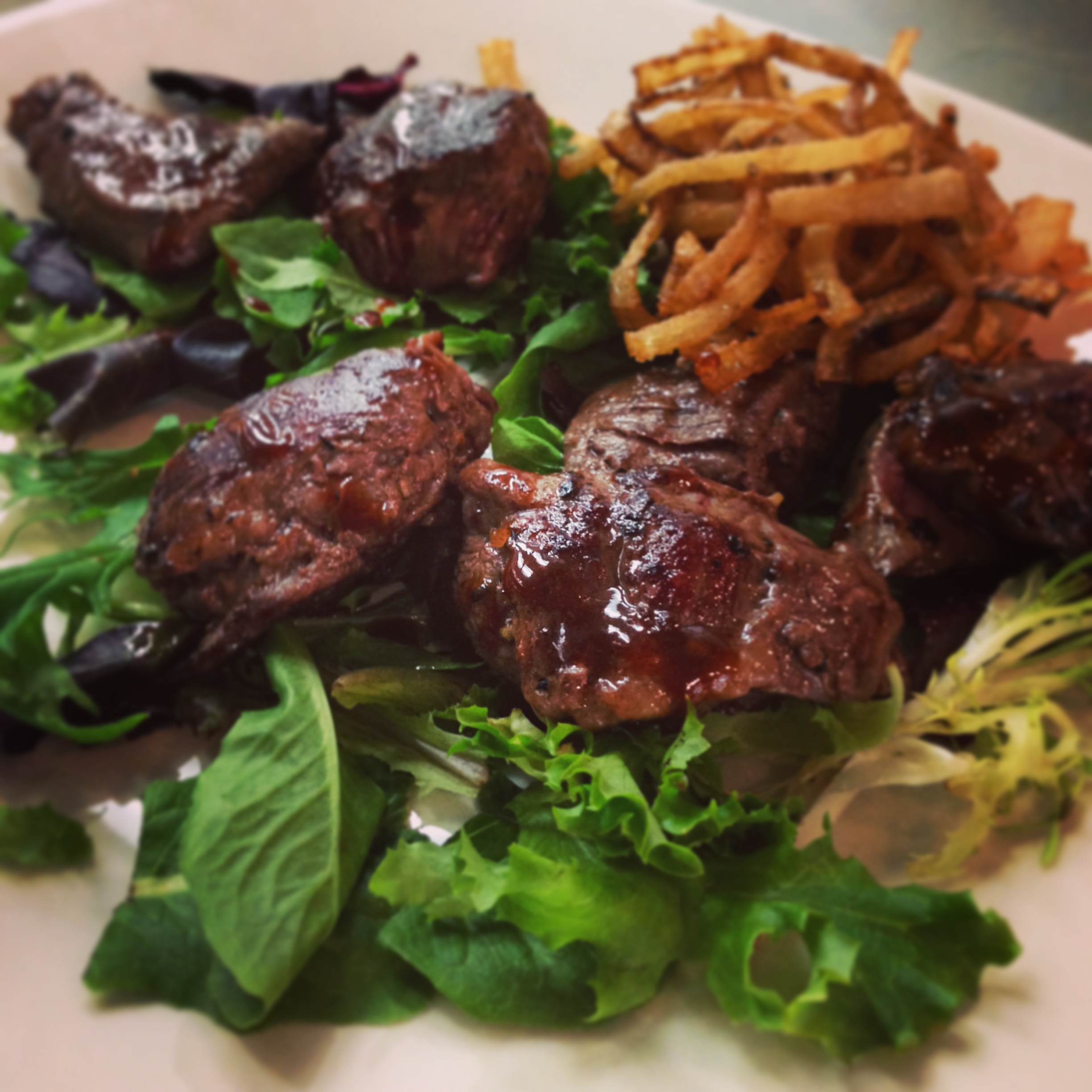 A Signature Item at The Barlow Room: Steak Bites with Fried Onions.