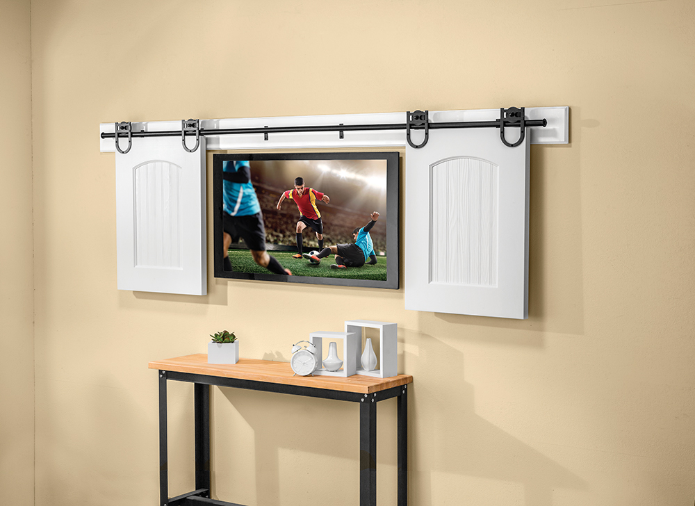 The Horseshoe Rolling Barn Door Hardware shown here is being used to conceal a flat panel TV.