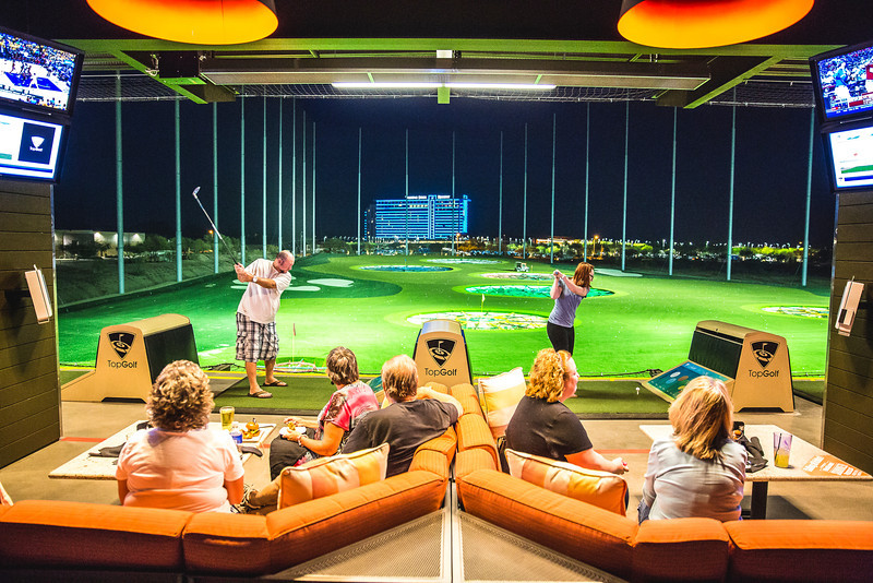 Guests lounging in their hitting bays at Topgolf Scottsdale at Riverwalk