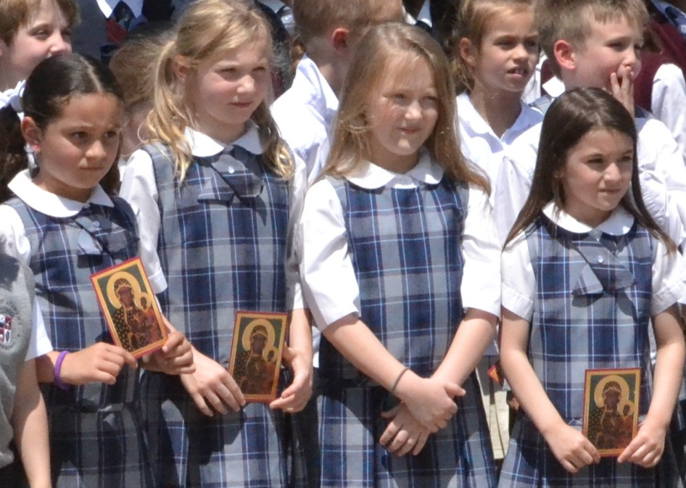 Fourth grade students pray reverently as they look upon the traveling Madonna.
