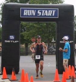 A triathlete crosses the finish line during the Morrison Family YMCA’s Adult Tri Ballantyne.