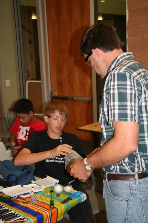 Christian Kinsey instructs camper in making amplifier with recycled materials at Roseville Utility with Sierra College STEM support.