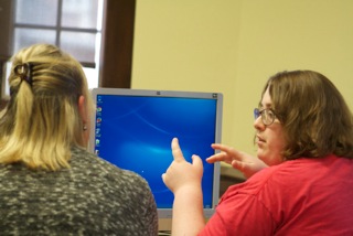EnCircle Technologies student Savannah, right, thinks through her assignment with staff.