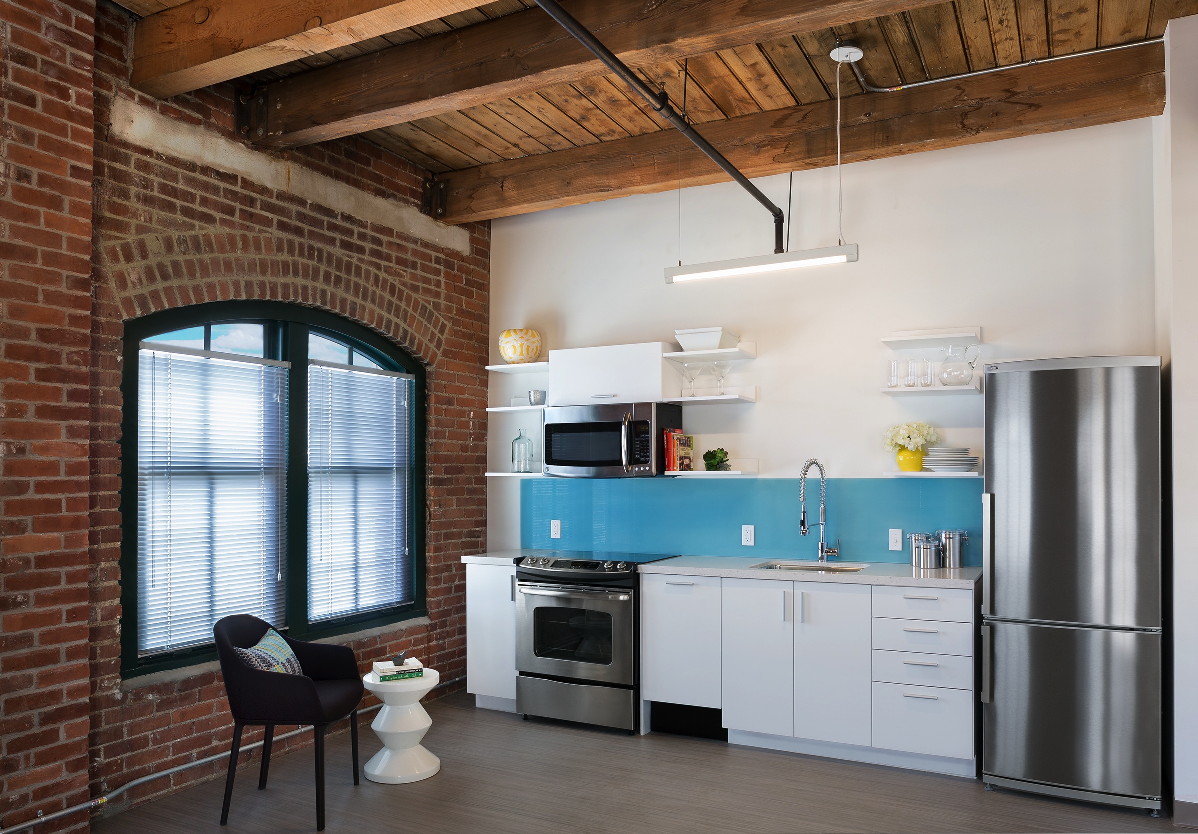 Contemporary amenities include modern kitchens with stainless steel appliances and stone countertops, ceramic tiled bathrooms with mounted designer sinks and oversized windows.