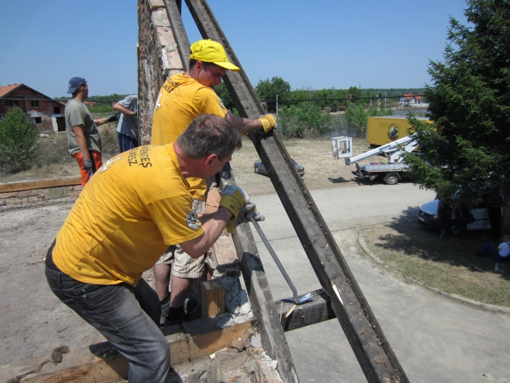 Scientology Volunteer Ministers extract beams from a condemned home in the village of Kopanica, in Bosnia and Herzegovina.