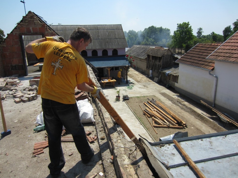 A Scientology Volunteer Minister assists with the salvage of useable building materials from a condemned home in the village of Kopanica, in Bosnia and Herzegovina.