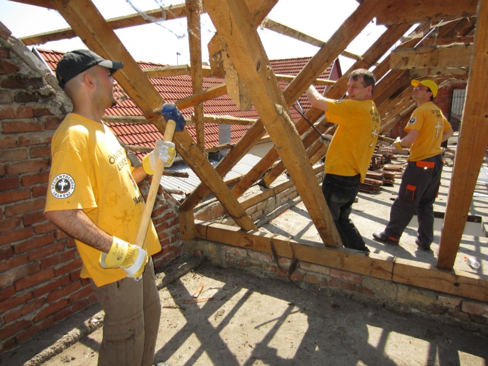 Scientology Volunteer Ministers retrieve beams from a condemned home in the village of Kopanica, in Bosnia and Herzegovina.