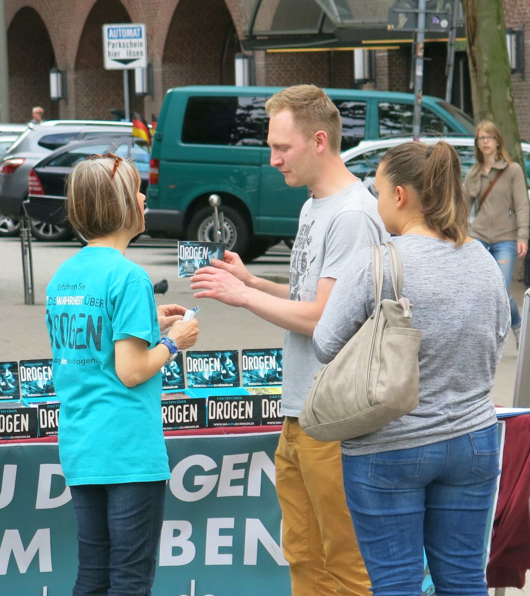A volunteer from the Church of Scientology of Hamburg shows The Truth About Drugs booklet to a visitor to a drug education information booth.