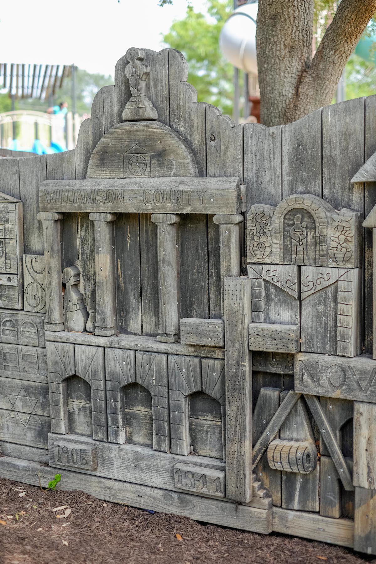 Carved wood panels from the original playground are integrated into the new play area