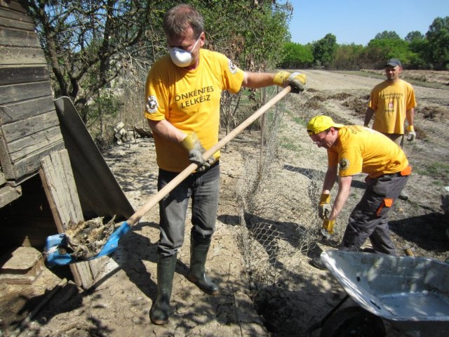 Wearing gloves and masks, the Scientology Volunteer Ministers clean out and dispose of dead animals at a pigsty and chicken farm in the Bosnian village of Kopanica.