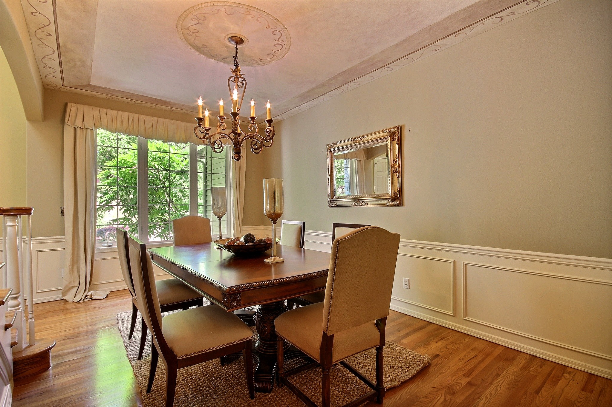 Formal Dining Room with Artisan Paintings and Wrought Iron Chandelier