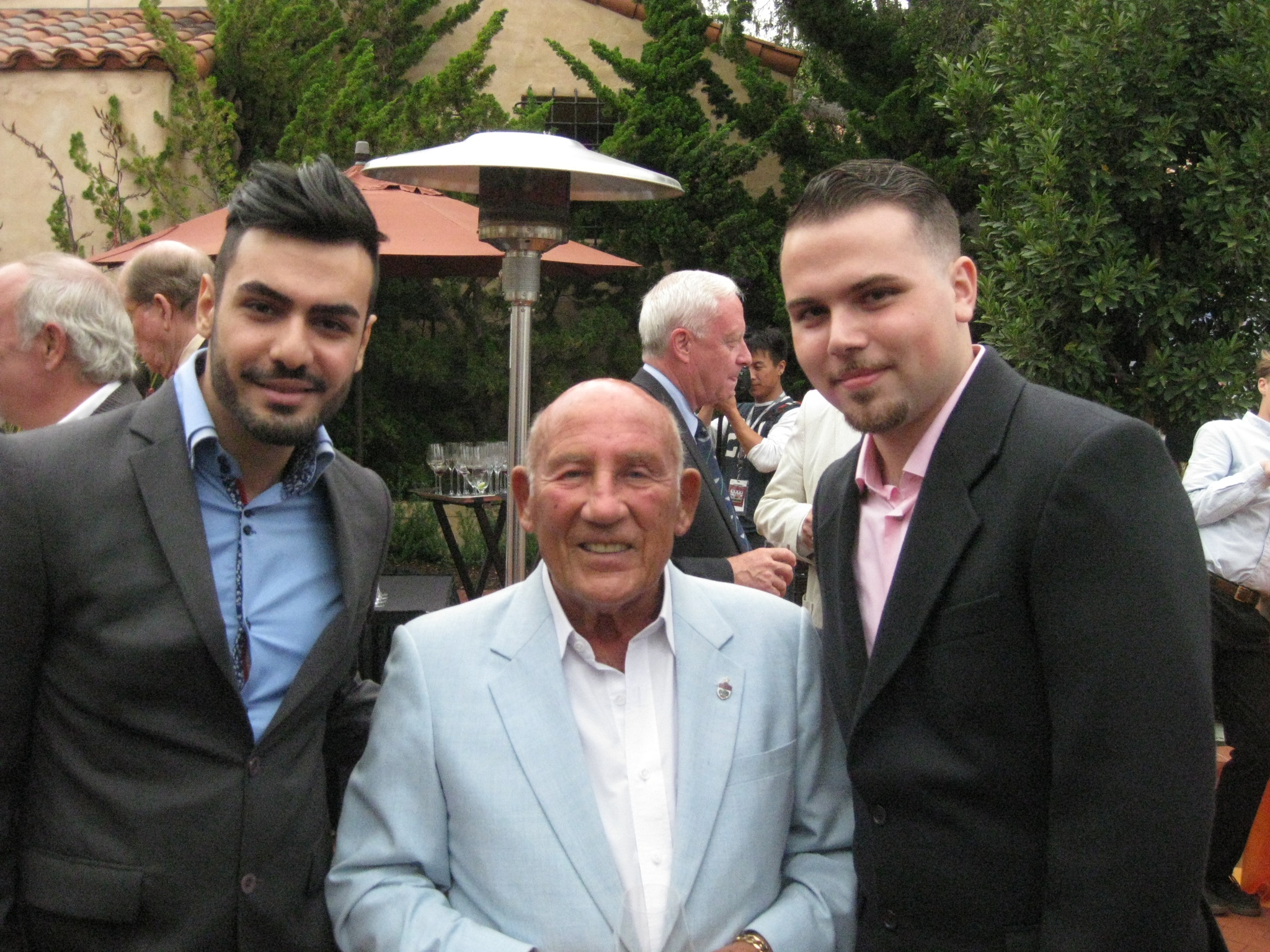 Phil Hil Scholarship Recipients Haman Ezzati and Ali Moosavi with Sir Stirling Moss at the Pebble Beach Concours d'Elegance.