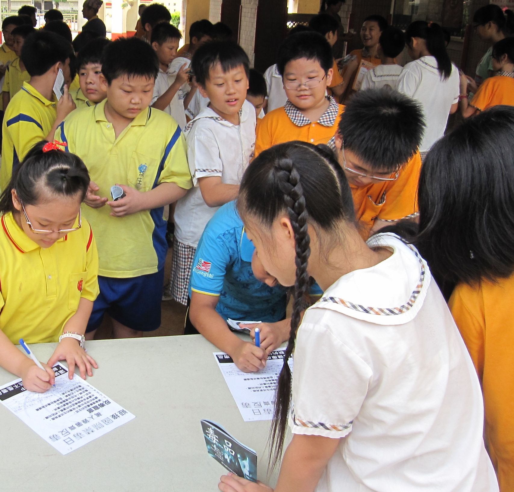 Gyugong Elementary School pupils sign a drug-free pledge, in a program organized by the Church of Scientology of Kaohsiung.