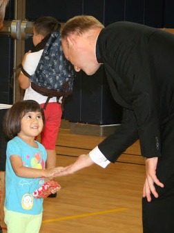 Father Thomas, LC greets a Everest preschool student.