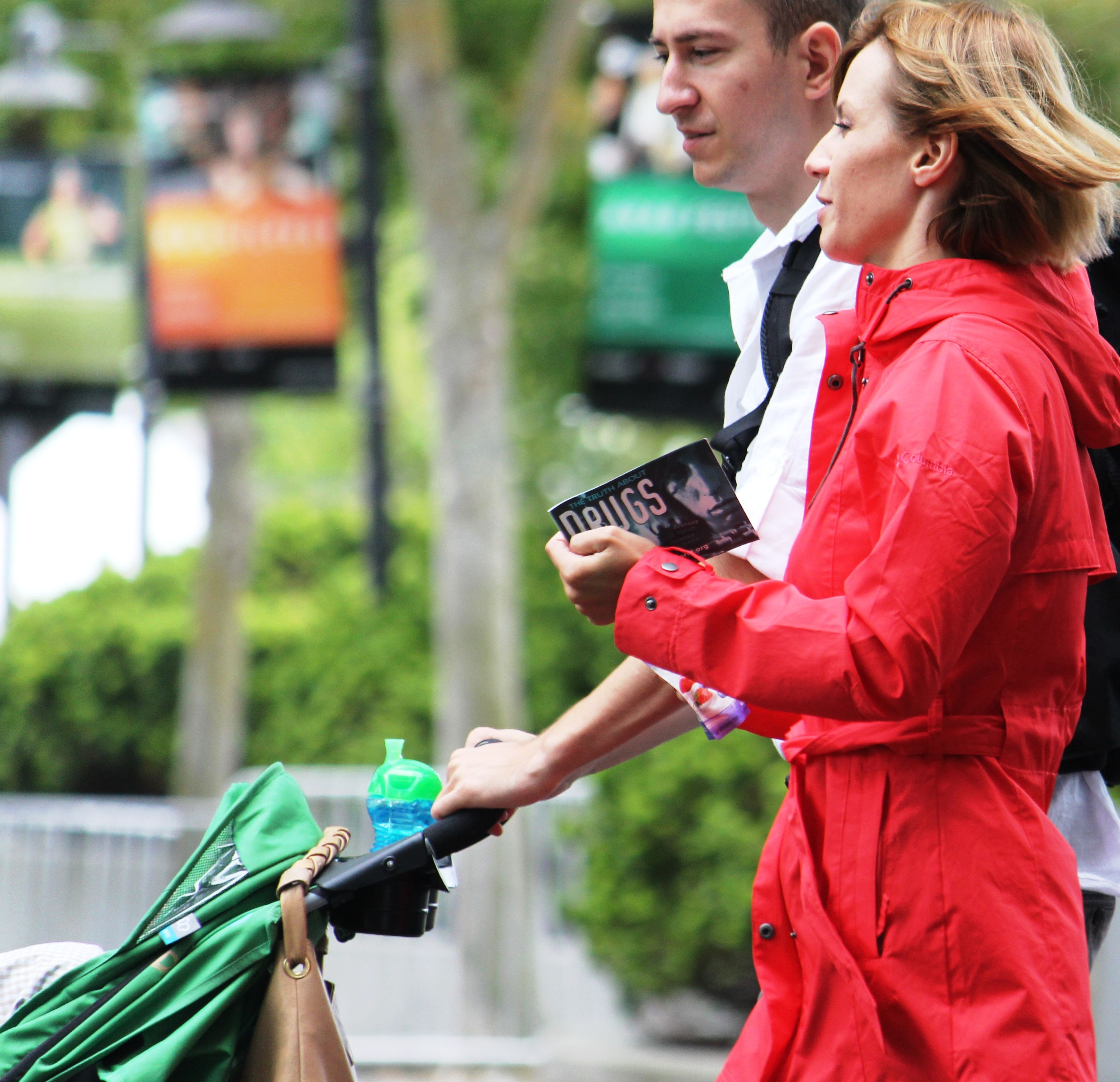 A young couple takes a stroll, carrying a copy of The Truth About Drugs booklet they received from a volunteer from the Church of Scientology of Seattle.
