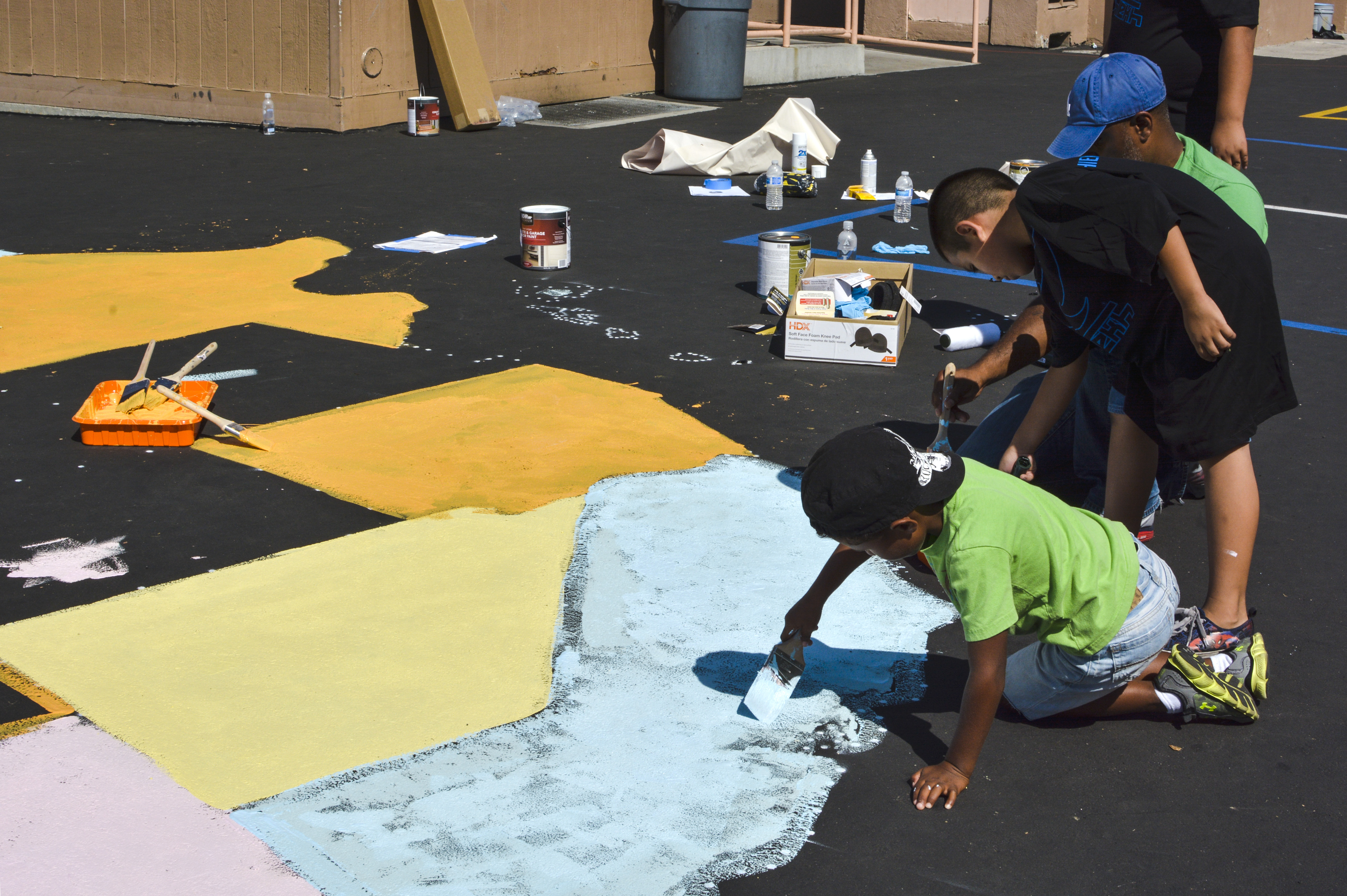 Mayo Elementary School students paint a map of the United States on the school's playground Saturday, Sept. 6, at the Timberland and Shiekh Shoes "Back to New" beautification project.