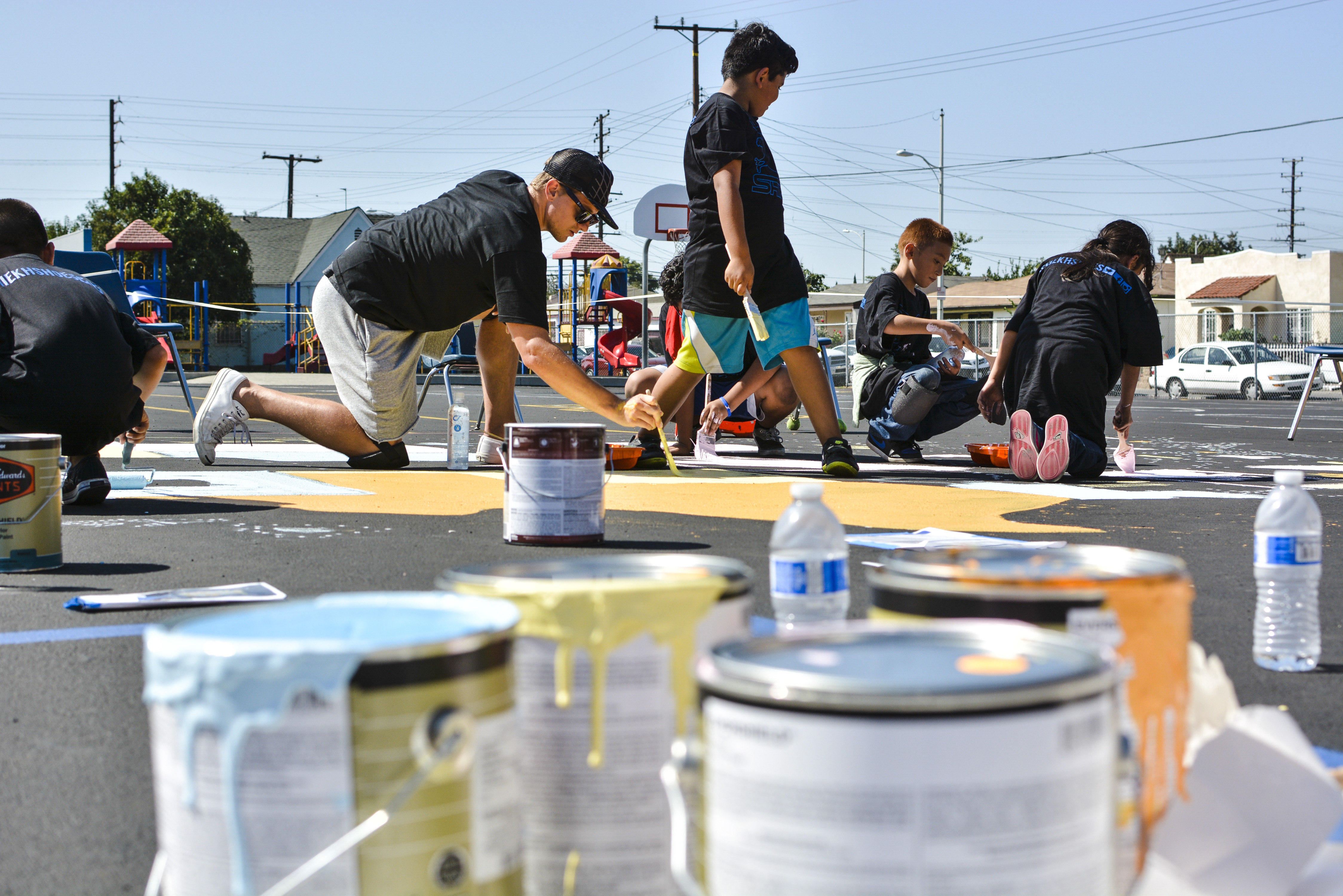 Mayo teachers and students and brand representatives paint a map of the United States on the school's playground Saturday, Sept. 6, at the Timberland and Shiekh Shoes "Back to New" beautification.