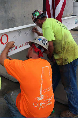 Clayco Inc. construction workers sign the final beam.