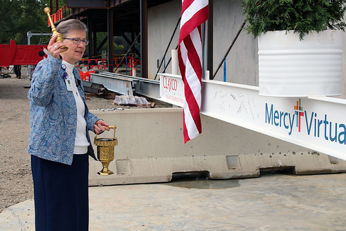 Sister of Mercy Claudia Ward blesses the final beam before it's raised.