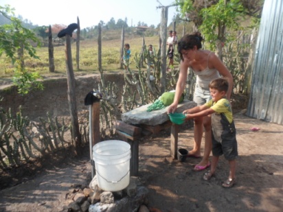 A sponsored family in Honduras washes clothes with water collected from a river nearby.