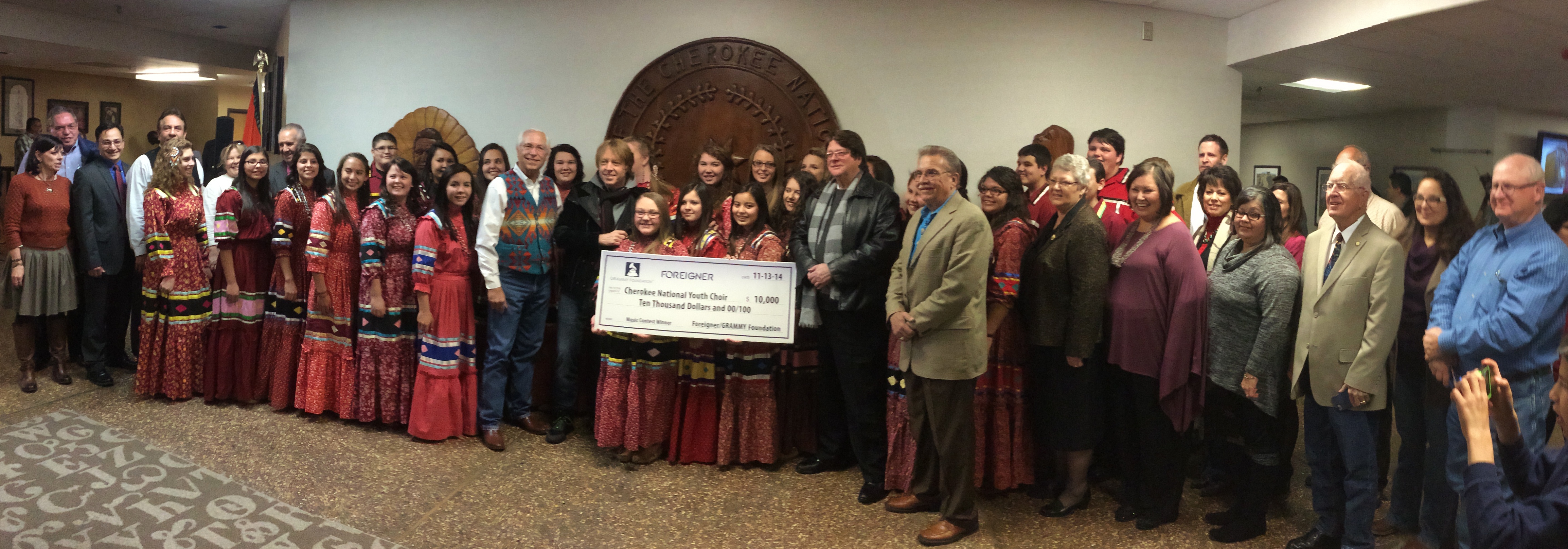 (L to R) Cherokee Nation Tribal Councilors Julia Coates and Jack Baker, Secretary of State Chuck Hoskin Jr., Tribal Councilors Frankie Hargis and Curtis Snell, Principal Chief Bill John Baker, Foreigner Bassist Jeff Pilson and Manager Phil Carson, and Tribal Council Speaker Tina Glory-Jordan, Cherokee National Youth Choir Director Mary Kay Henderson, Tribal Councilors David Walkingstick and Victoria Vazquez, choir Language Program Coordinator Kathy Sierra and Tribal Councilors Janees Taylor, Don Garvin, Lee Keener, Cara Cowan Watts and Dick Lay congratulate the choir for winning the GRAMMY Foundation contest.