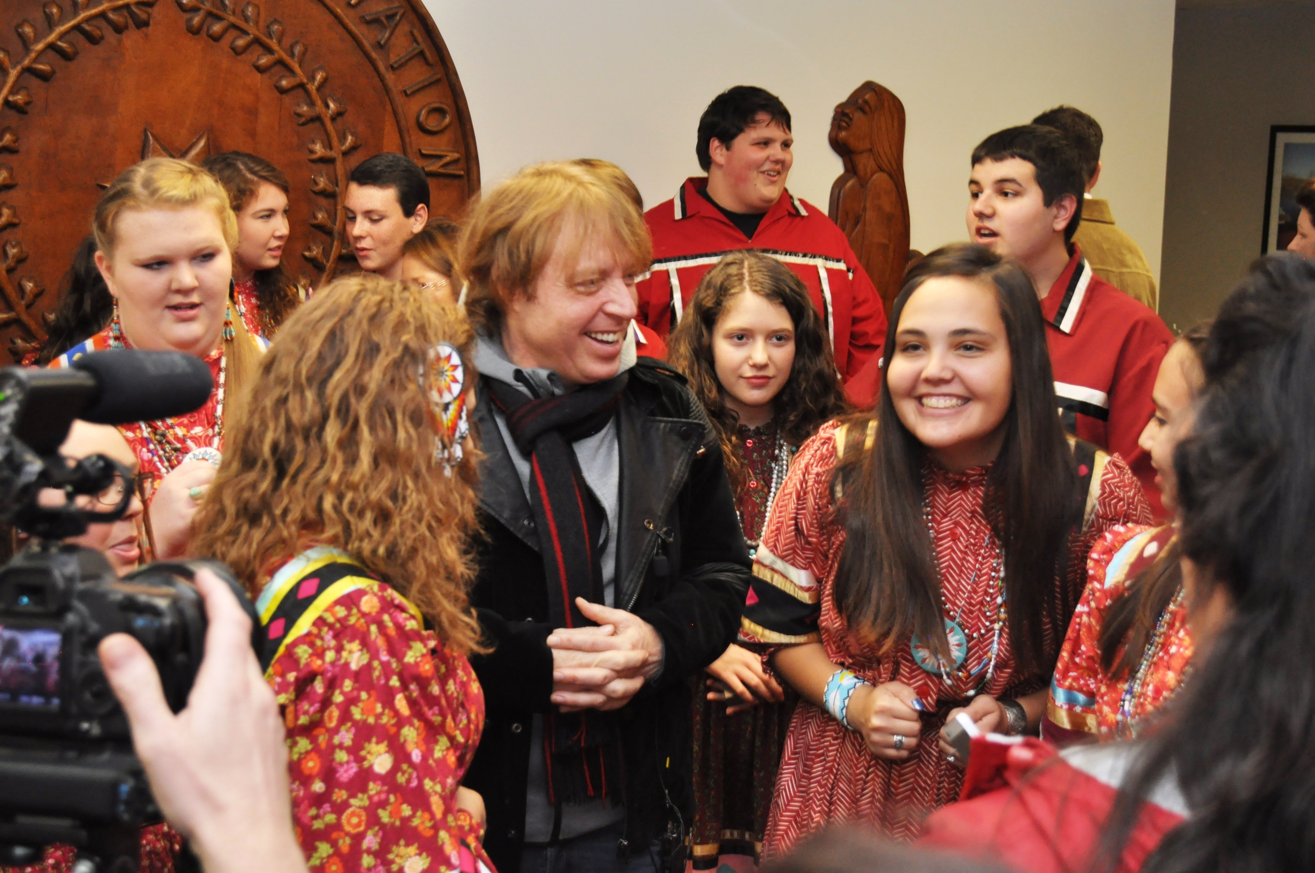 Cherokee National Youth Choir members gather around Foreigner Bassist Jeff Pilson for photos.