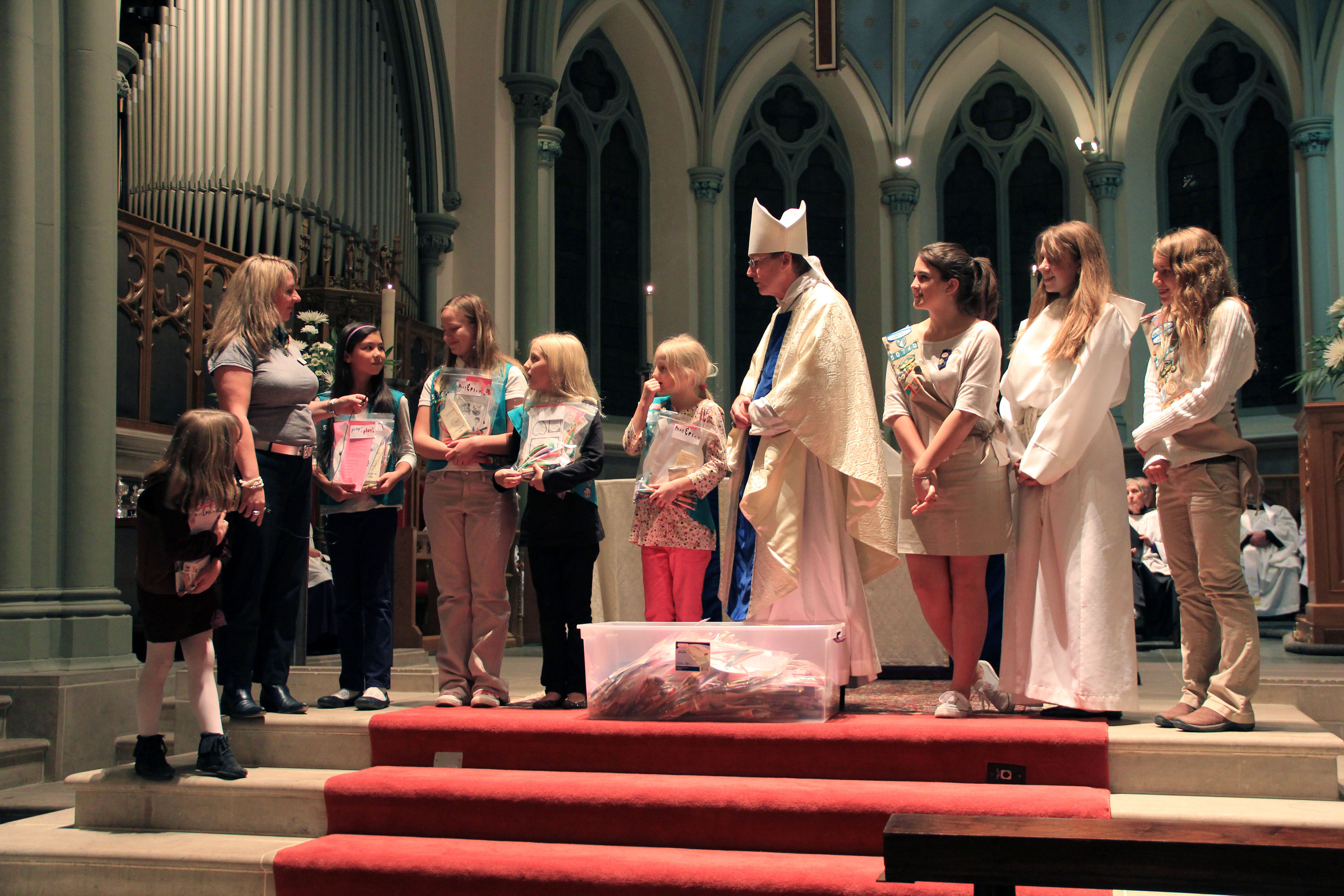 Girl Scouts from Troop 57003 and Troop 50740 present The Rt. Rev. Dorsey McConnell, Bishop of the Episcopal Diocese of Pittsburgh with 100 “Pray & Play” bags and explain their usage.