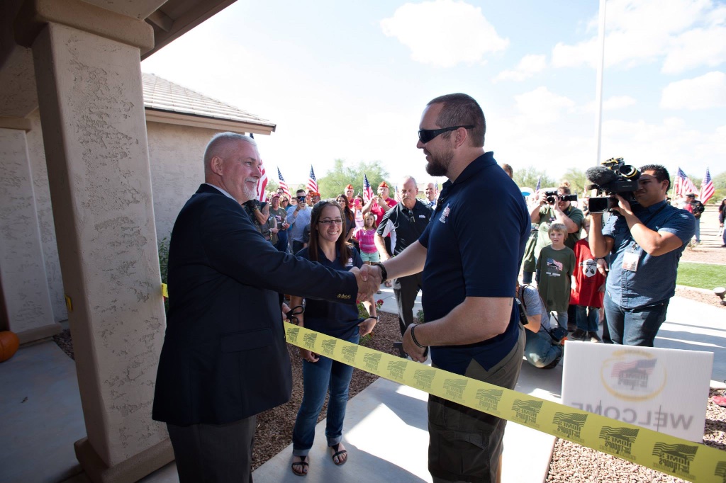 Marine Sergeant Robert Bruce shakes the hand of Homes for Our Troops Veteran Liasion Larry Gill as Sgt. Bruce's wife watches during the November 15 ribbon cutting.