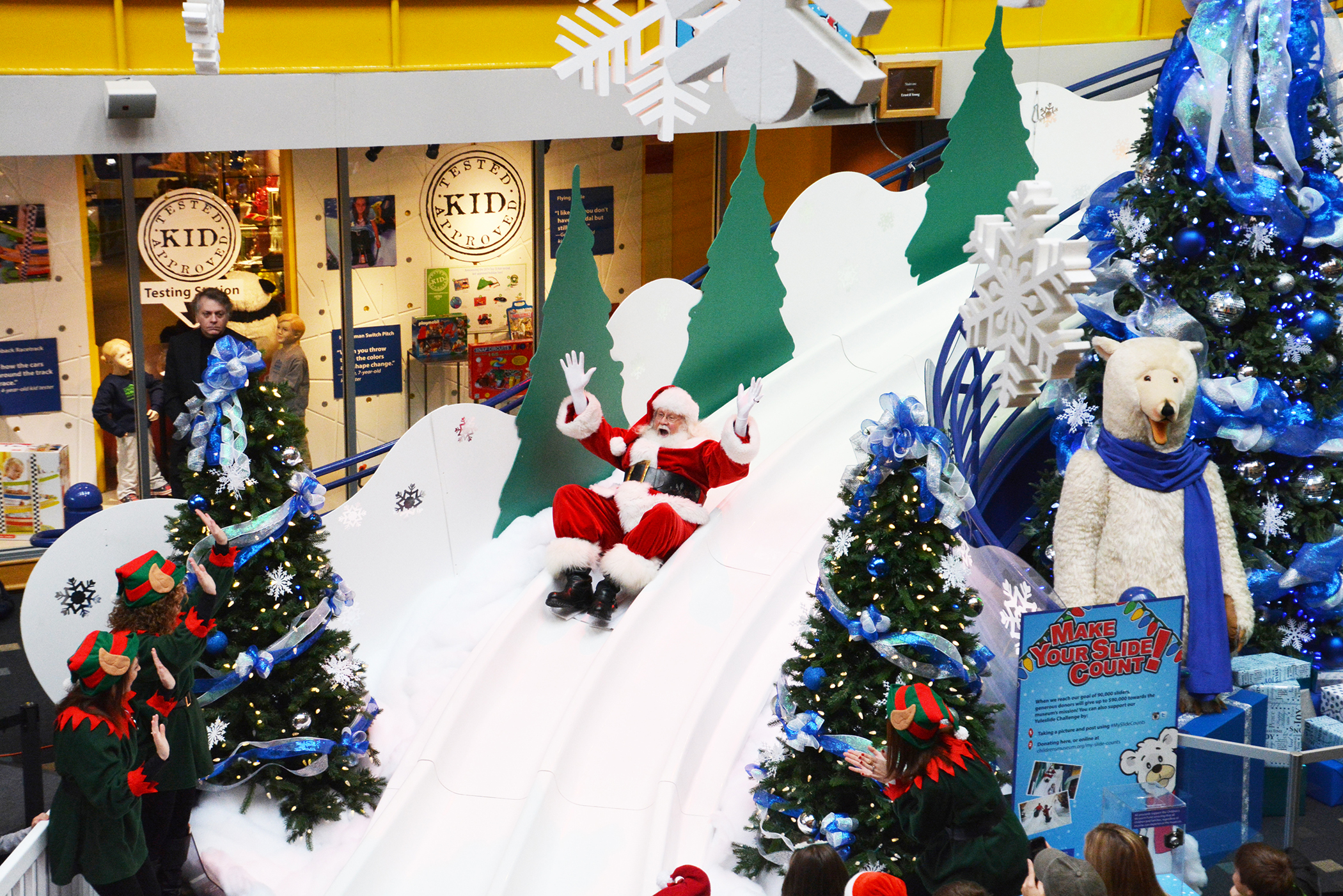 Santa zips down the Yule Slide at The Children's Museum of Indianapolis