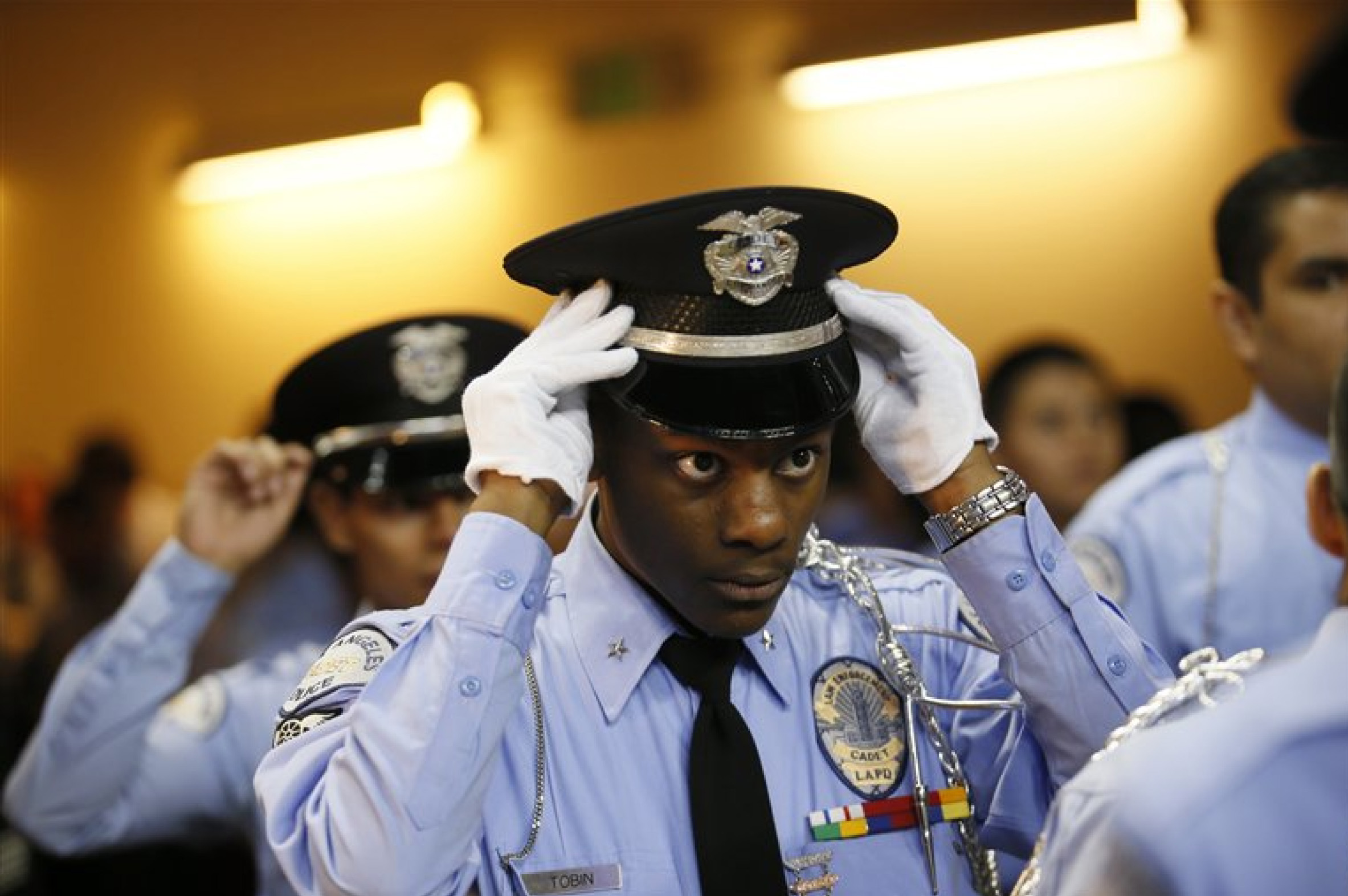 LAPD Cadet Commander adjusts his hat at the LAPD Cadet Program graduation, partly funded by $1.5M in grants from the Ray Charles Foundation.